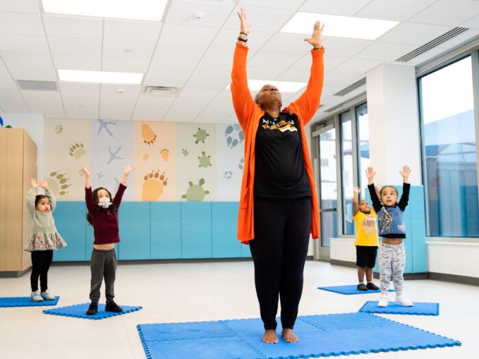 A teacher stretching with preschool children in mindfulness exercise